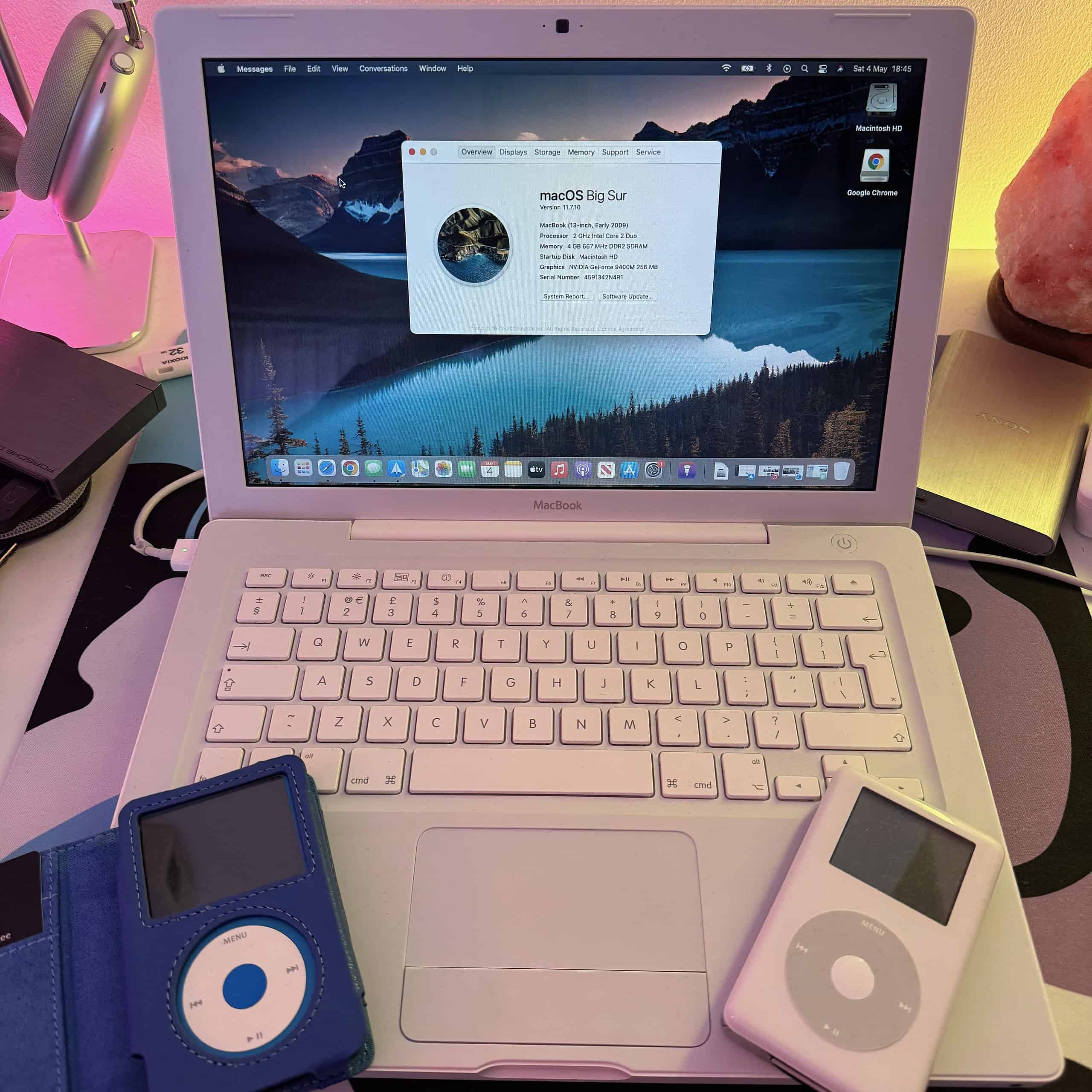 2007 MacBook White running macOS 11 Big Sur with OCLP and two vintage iPods over its palm rest